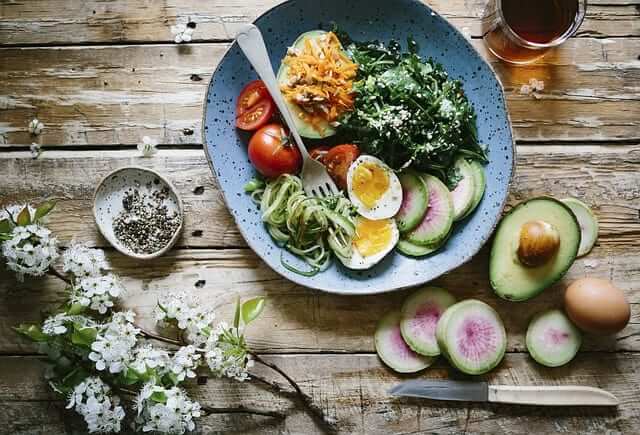 healthy bowl with veggies, avocados and eggs 