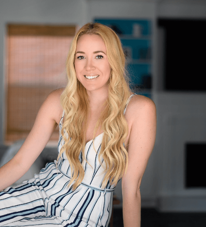 blonde woman in a striped dress against a faded living room background