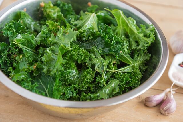 fresh kale leaves in a metal salad bowl