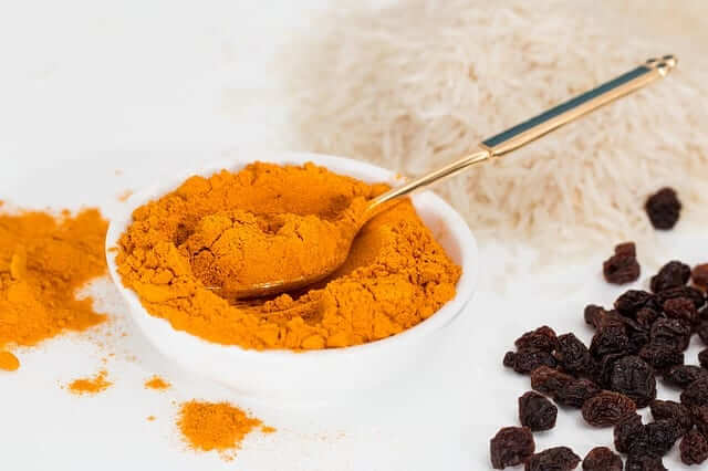 turmeric powder in a small white bowl (anti-inflammatory foods list)
