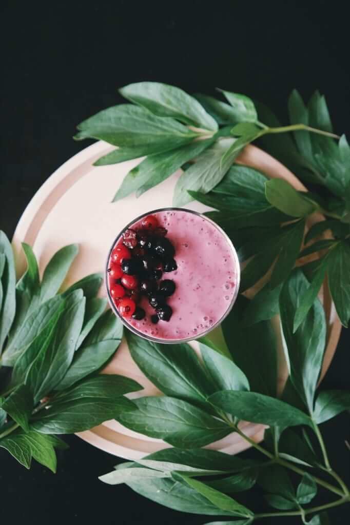 Overhead shot of a homemade healthy smoothie topped with berries - healthy smoothie recipes