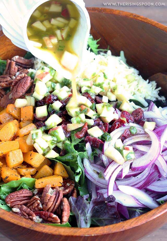 Paleo Salad with butternut squash and apples being mixed in a bowl