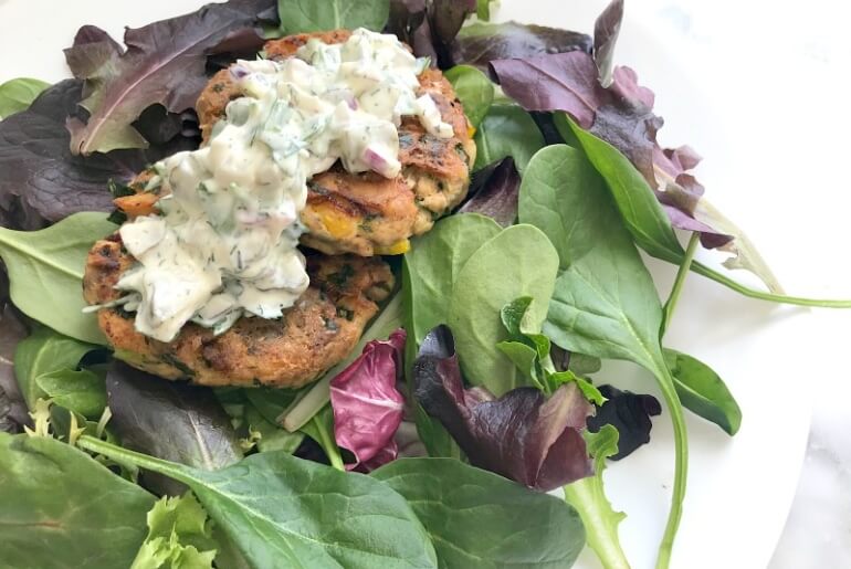 healthy salmon cakes served on leafy greens