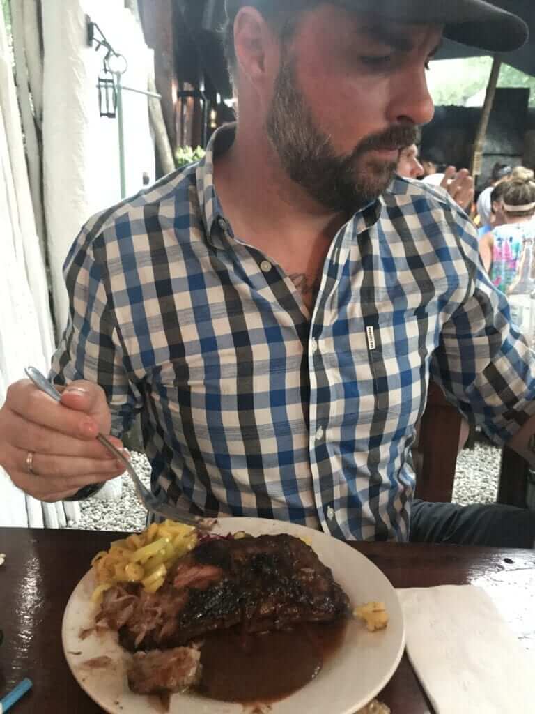 a man eating ribs at Hartwood restaurant Tulum 