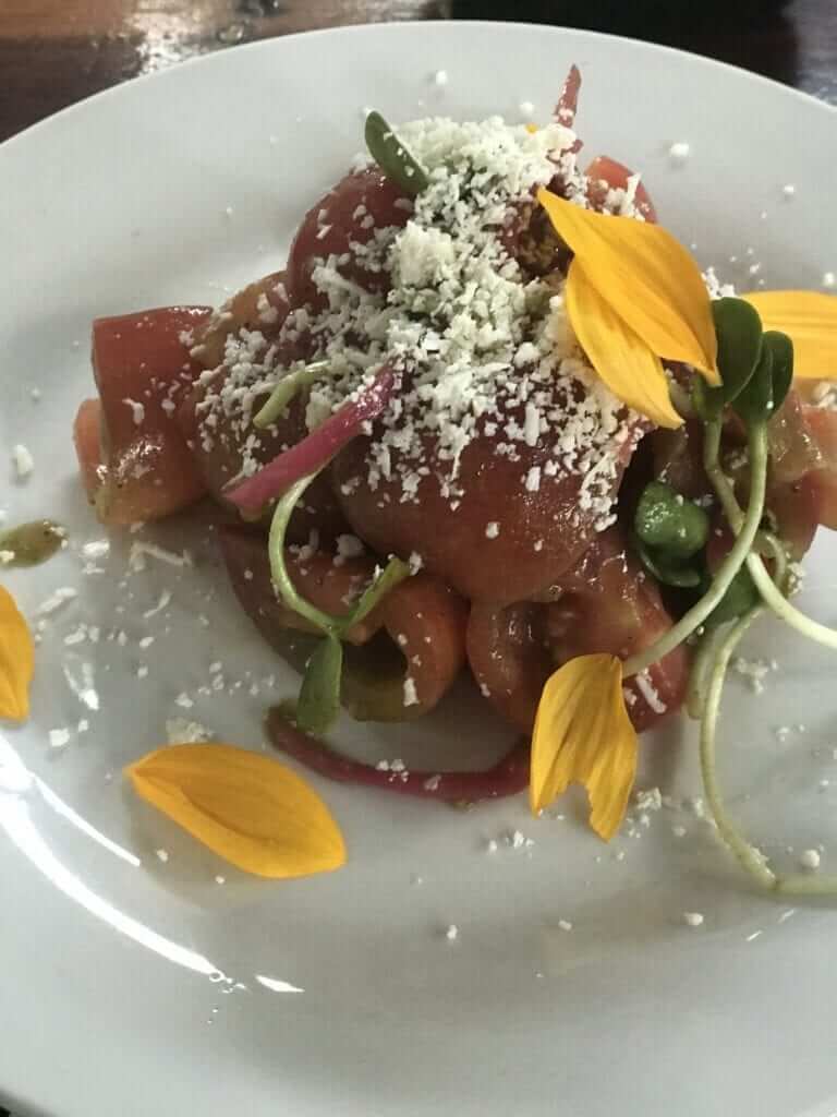 side view of tomato salad at Hartwood Tulum