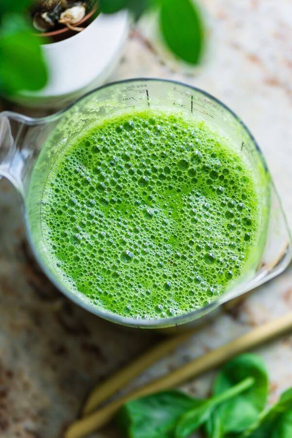 overhead shot of a homemade healthy green smoothie with collagen avocado blueberries and spinach 