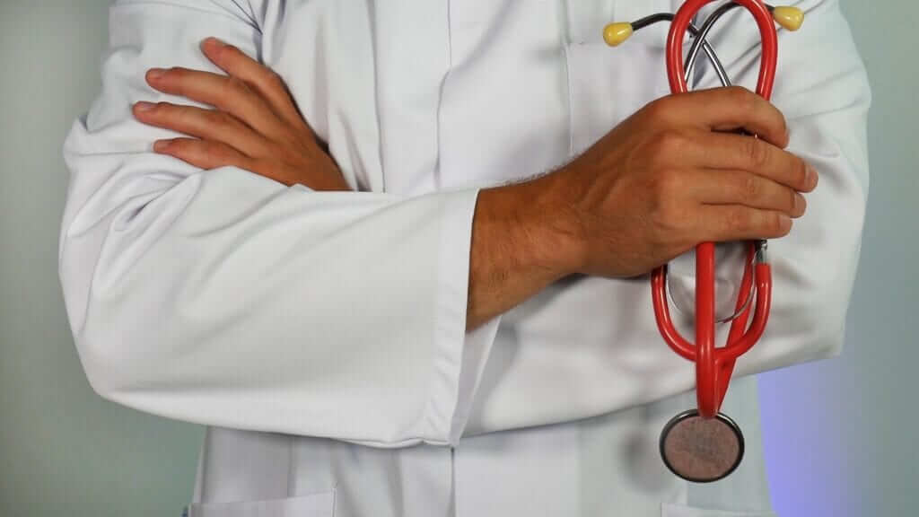 a doctor with crossed arms holding a stethoscope 