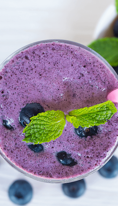 overhead shot of a healthy blueberry smoothie that helps to prevent stretch marks 