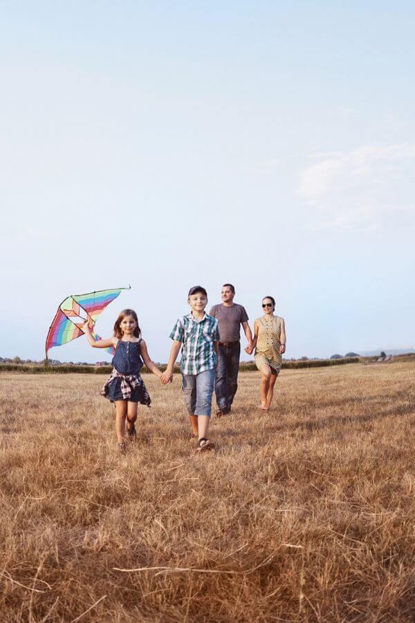 a family taking a walk with their kids in a farmers field 