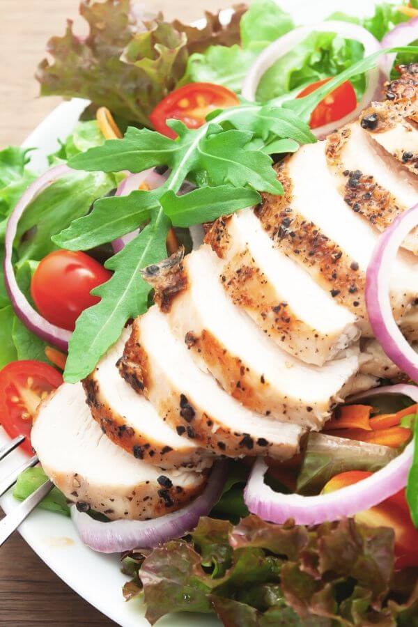 close-up of a healthy chicken salad with arugula and red onion 